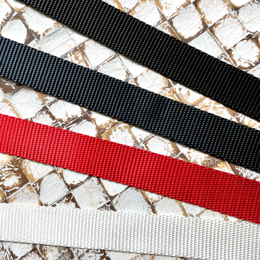 Four webbing straps in black, navy, red, and white
