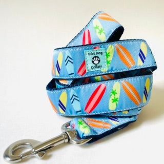 A coiled blue dog leash with a colorful surfboard pattern and a rust proof stainless clip made for the beach dog