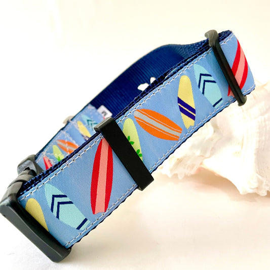 A blue fabric dog collar with a colorful surfboard pattern, brand 'Wet Dog Collars' and rust proof D-ring