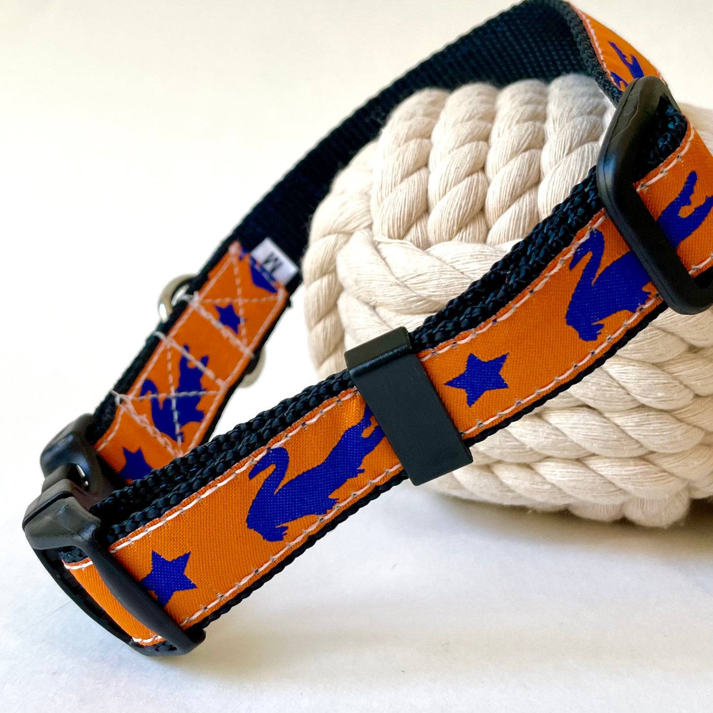 Dog collar with orange and blue gator pattern on a white background