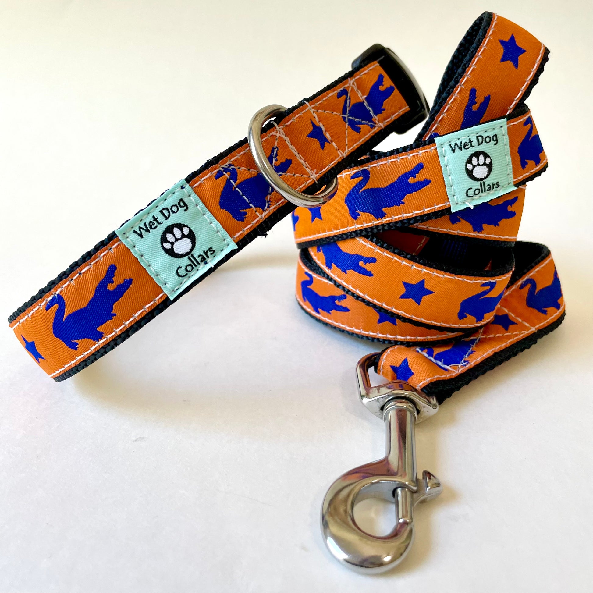 Dog collar and leash set with blue gator and star pattern on orange background, brand 'Wet Dog Collars' visible.