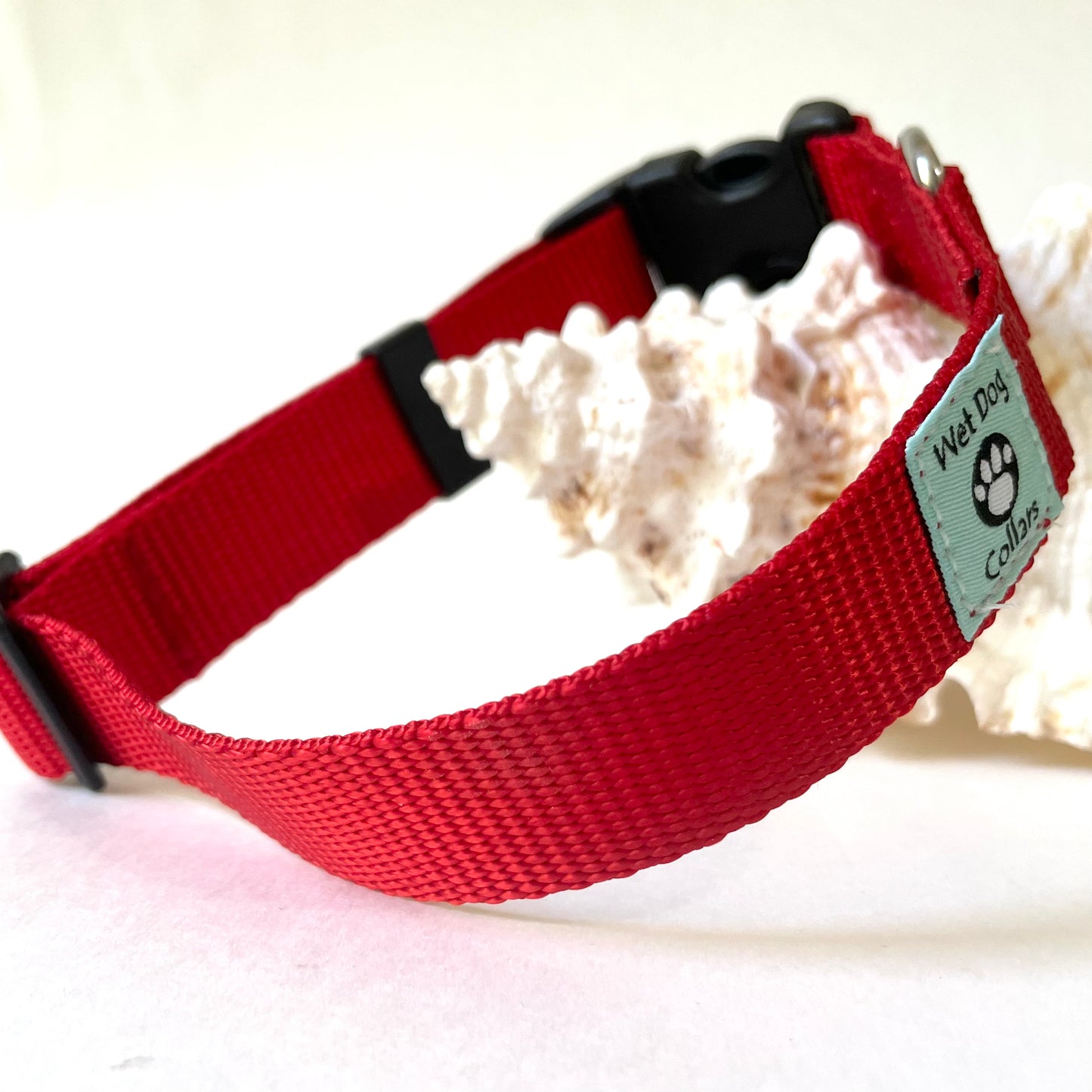 Red dog collar with a brand Wet Dog Collars tag on a white background