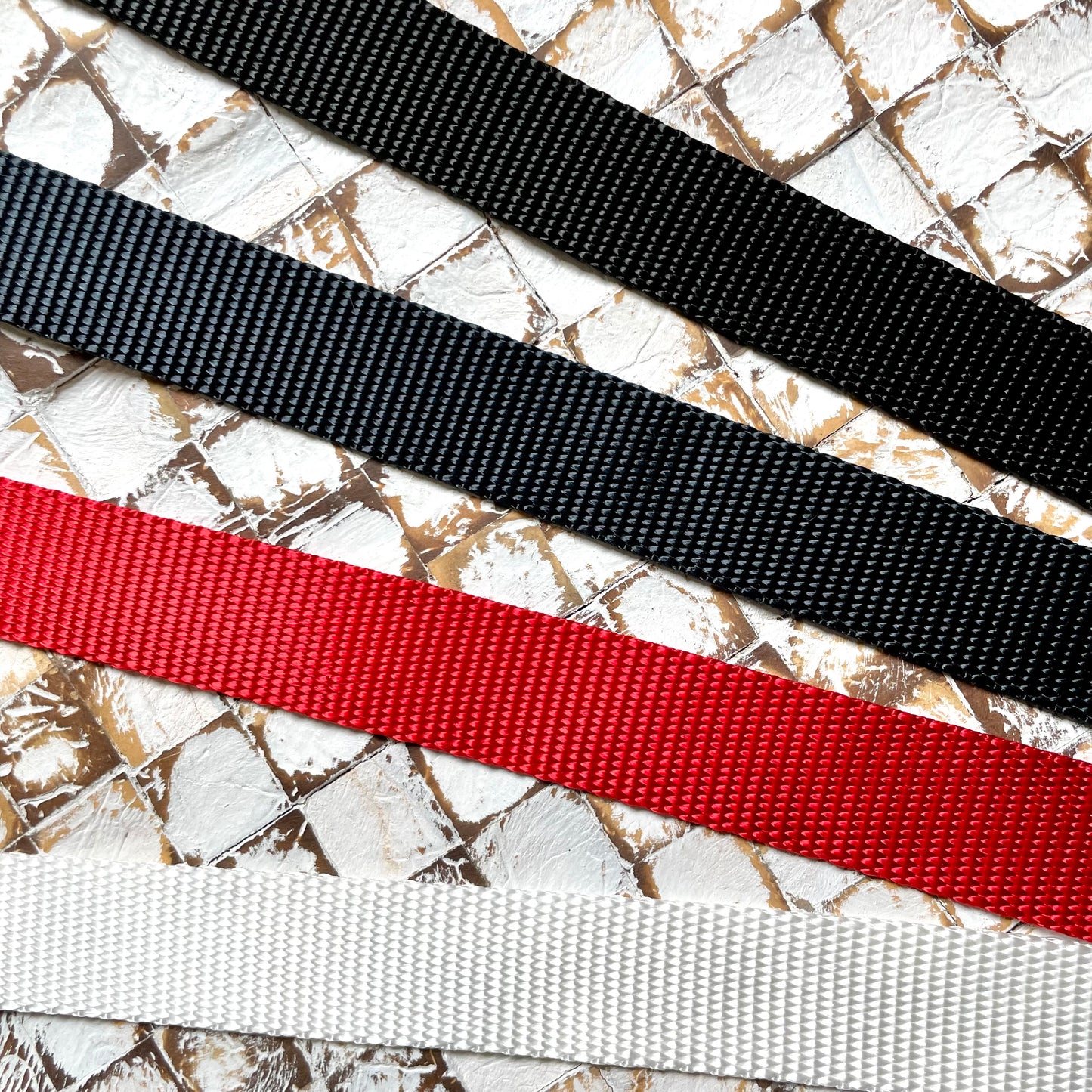 Four webbing straps in black, navy, red, and white 