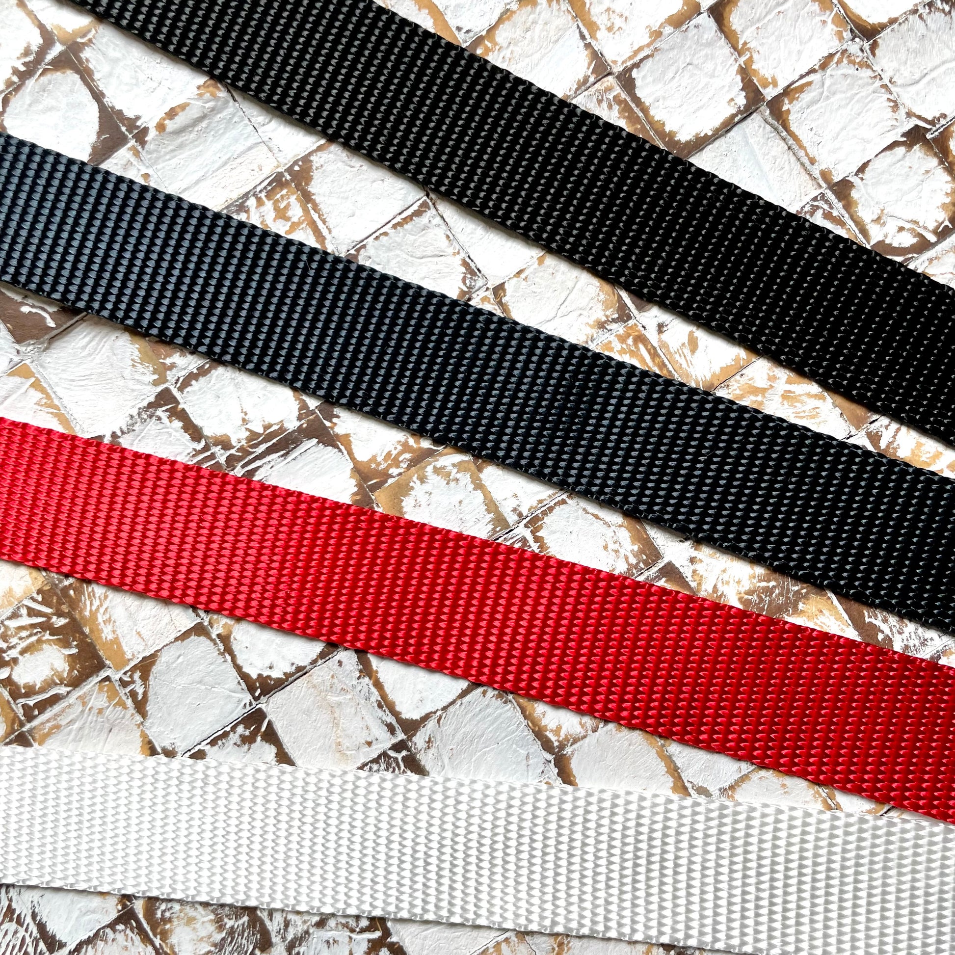 Four webbing straps in black, navy, red, and white 