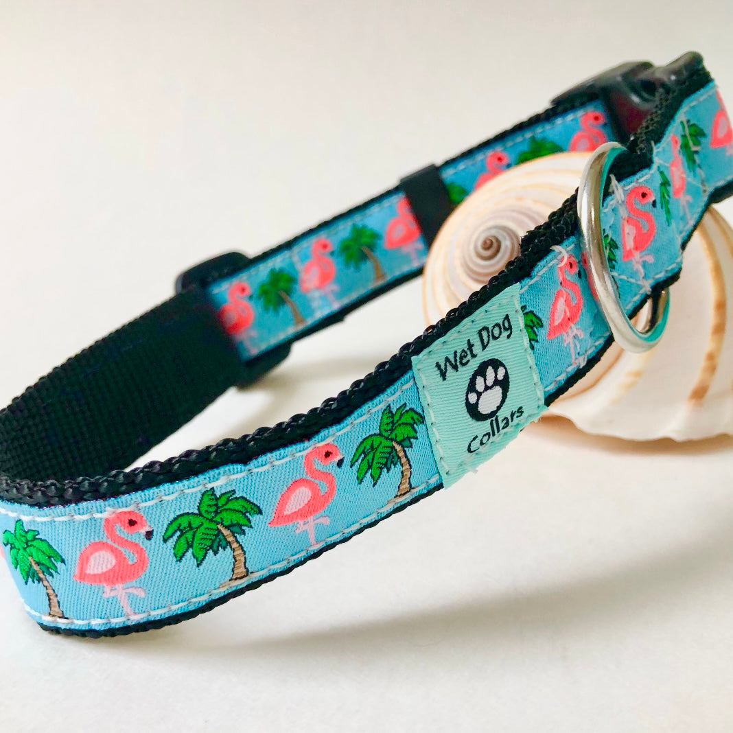 Dog collar with flamingo and palm tree pattern on a light blue background, featuring the brand 'Wet Dog Collars'.