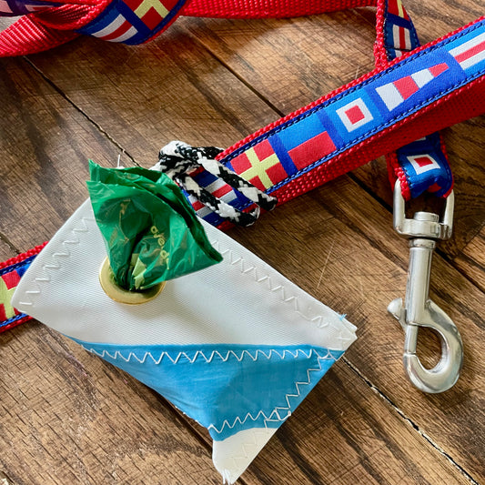 Dog leash with colorful flag pattern and dog bag holder on a wooden surface