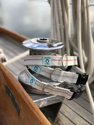 Sailboat pulley system with a winch and ropes on a wooden deck.